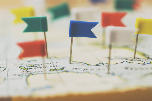 Flag shaped push pin in a vintage travel map. travel destination