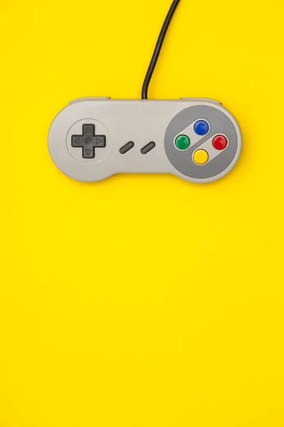 Контроллер ретро-компьютерных игр на ярком желтом фоне — стоковое фото