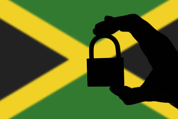 Jamaica Sicherheit. Silhouette der Hand hält ein Vorhängeschloss über nati — Stockfoto