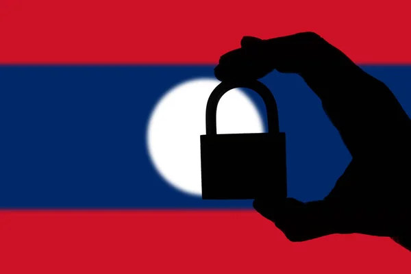 Laos güvenliği. Nationa üzerinde bir asma kilit tutan el silueti — Stok fotoğraf