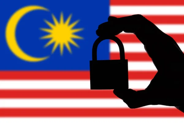 말레이시아 보안. 자물쇠를 들고 있는 손의 실루엣 — 스톡 사진