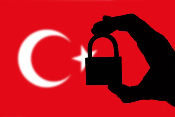 Turkey security. Silhouette of hand holding a padlock over natio — Stock Photo, Image