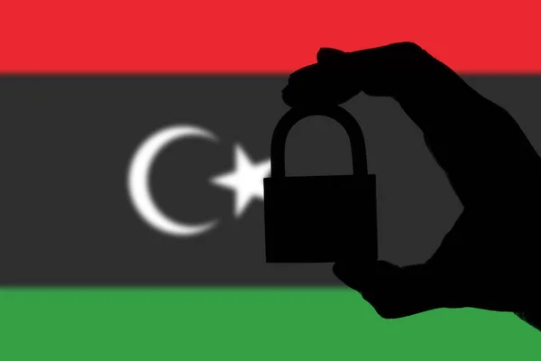 Säkerhet i Libyen. Silhuett av handen håller ett hänglås över nation — Stockfoto