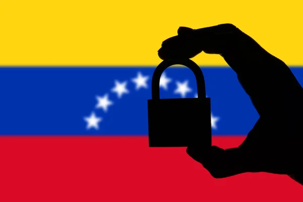 Sécurité du Venezuela. Silhouette de la main tenant un cadenas au-dessus de na — Photo
