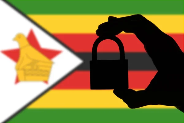 Zimbabwe veiligheid. Silhouet van de hand met een hangslot over NAT — Stockfoto