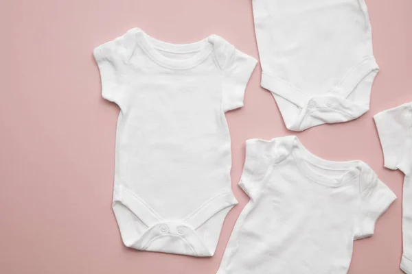 Carino bambino bianco corpo vestito layout su uno sfondo rosa pastello — Foto Stock