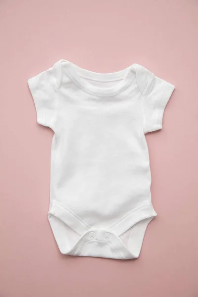 Cute baby white body suit layout on a pastel pink background — Stock Photo, Image