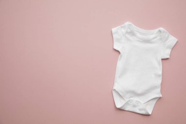 Pastel pembe arka plan üzerinde sevimli bebek beyaz vücut takım düzeni