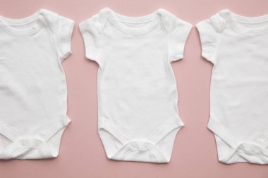 Pastel pembe arka plan üzerinde sevimli bebek beyaz vücut takım düzeni