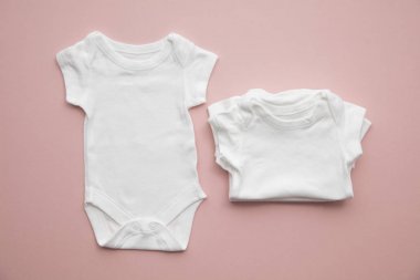 Pastel pembe arka plan üzerinde sevimli bebek beyaz vücut takım düzeni