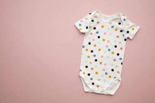 Mignon polka dot bébé corps costume disposition sur un fond rose pastel — Photo