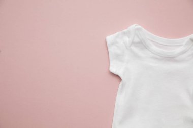 Pastel pembe arka plan üzerinde sevimli bebek beyaz vücut takım düzeni
