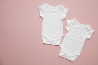 Pastel pembe arka plan üzerinde sevimli bebek beyaz vücut takım düzeni