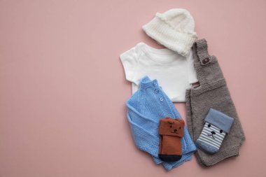 Pastel pembe arka plan üzerinde yenidoğan çocuk giyim düzeni