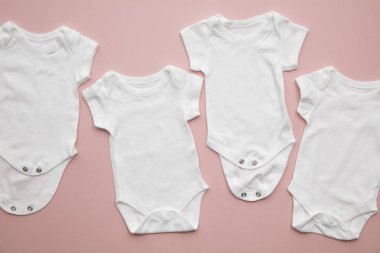 Cute baby white body suit layout on a pastel pink background clipart