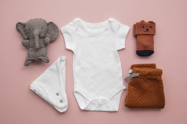 Pastel pembe arka plan üzerinde yenidoğan çocuk giyim düzeni