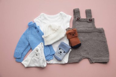 Pastel pembe arka plan üzerinde yenidoğan çocuk giyim düzeni