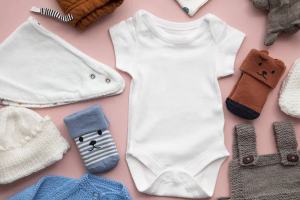 Mise en page des vêtements pour enfants nouveau-nés sur un fond rose pastel — Photo