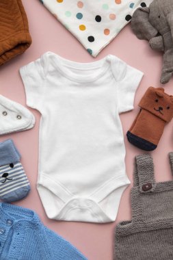 Pastel pembe arka plan üzerinde yenidoğan çocuk giyim düzeni