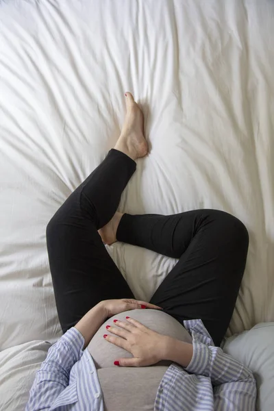 침대에 앉아 집에서 쉬고있는 젊은 임산부. 임산부 — 스톡 사진