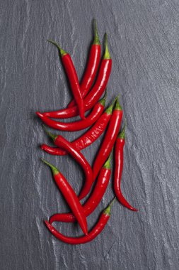 Koyu bir kayrak arka plan üzerinde kırmızı taze biber