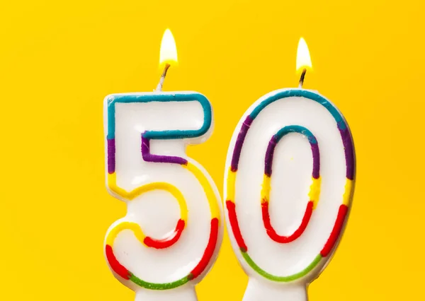 Numara 50 parlak sarı ba karşı doğum günü kutlama mum — Stok fotoğraf