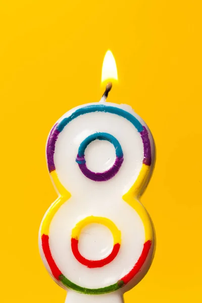 Vela de celebración de cumpleaños número 8 contra un bac amarillo brillante —  Fotos de Stock
