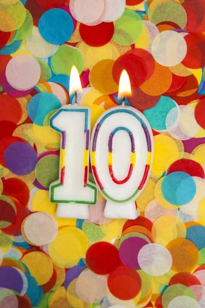 Vela de celebração número 10 em um fundo de confete — Fotografia de Stock