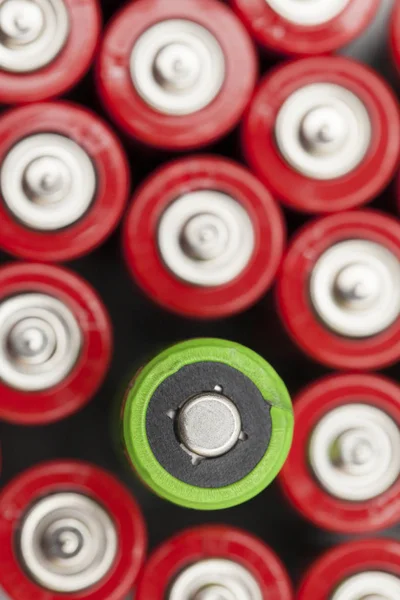 Batería verde se destaca contra las baterías rojas. Consumo de energía verde — Foto de Stock