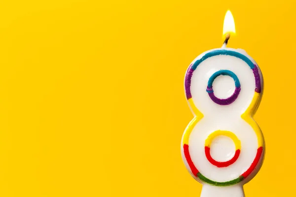 Číslo 8 narozeninová svíčka proti jasně žlutému BAC — Stock fotografie