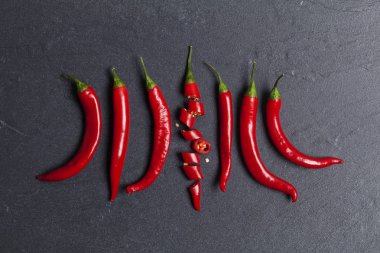 Kırmızı taze biber koyu bir kayrak backg üzerinde parçalar halinde doğranmış