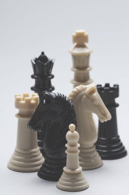 Gri bir arka plan üzerinde satranç oyunu parçaları. Strateji kavramı