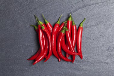 Koyu bir kayrak arka plan üzerinde kırmızı taze biber