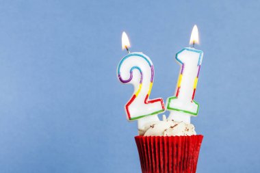 Mavi bir arka plan aleyhine bir cupcake içinde Sayı 21 doğum günü mum