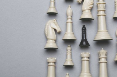 Gri bir arka plan üzerinde satranç oyunu parçaları. Strateji kavramı