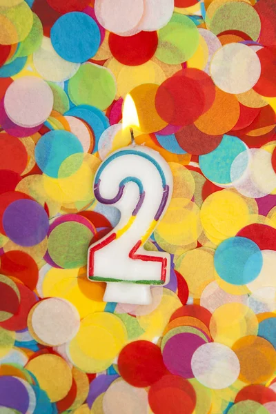 Vela de celebração número 2 em um fundo de confete — Fotografia de Stock