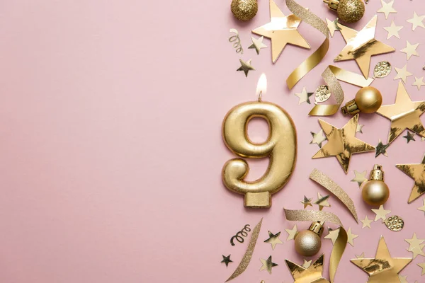 Nummer 9 gouden viering kaars op ster en glitter achtergrond — Stockfoto