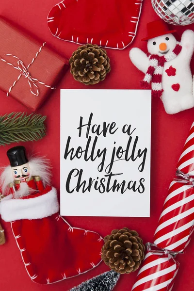 Festliche Botschaft auf weißem Papier mit einer Sammlung von Weihnachtsdekorationen — Stockfoto