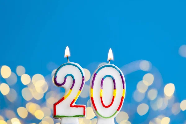 Number 20 birthday celebration candle against a bright lights an — Stock Photo, Image