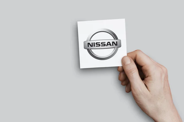 Londyn, Wielka Brytania-26 października 2018: ręka trzyma logo Nissan. NISS — Zdjęcie stockowe