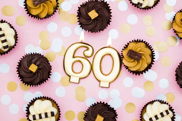 파스텔 핑크 백그에 컵케이크가 달린 60번 골드 캔들 — 스톡 사진