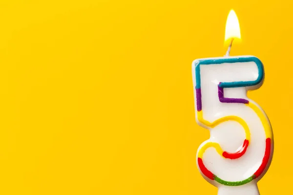 Number 5 birthday celebration candle against a bright yellow bac — Stock Photo, Image