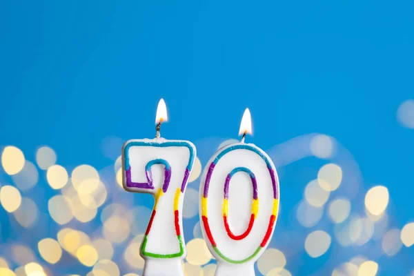 Número 70 vela de celebración de cumpleaños contra una luz brillante un —  Fotos de Stock