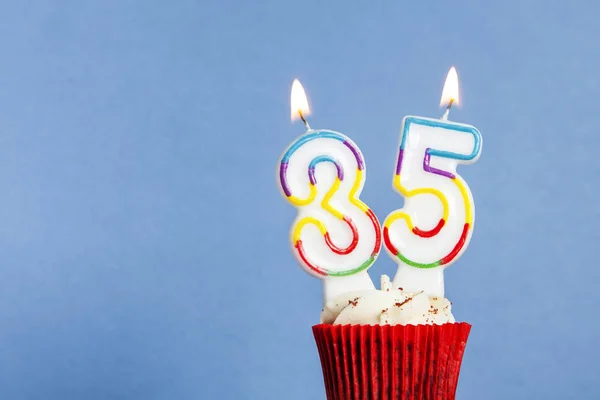 Bougie d'anniversaire numéro 35 dans un cupcake sur un fond bleu — Photo