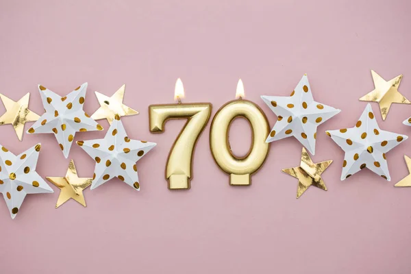 Nummer 70 gouden kaars en sterren op een pastel roze achtergrond — Stockfoto