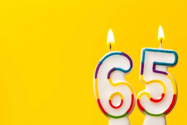 Sayı 65 parlak sarı ba karşı doğum günü kutlama mum — Stok fotoğraf