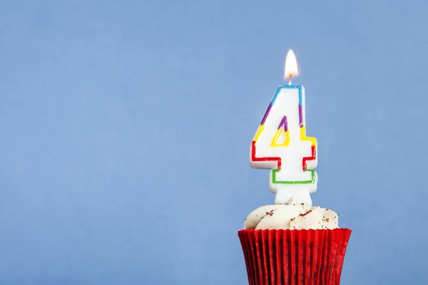 파란색 배경에 대한 컵 케이크에 번호 4 생일 촛불 — 스톡 사진
