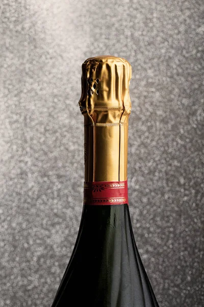 Láhev šampaňského na třpytivou pozadí — Stock fotografie