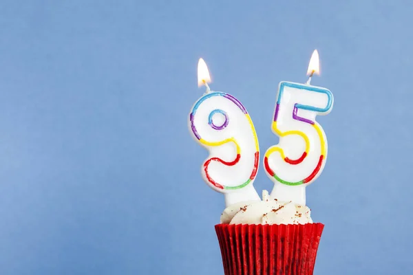 Nummer 95 Geburtstagskerze im Cupcake vor blauem Hintergrund — Stockfoto