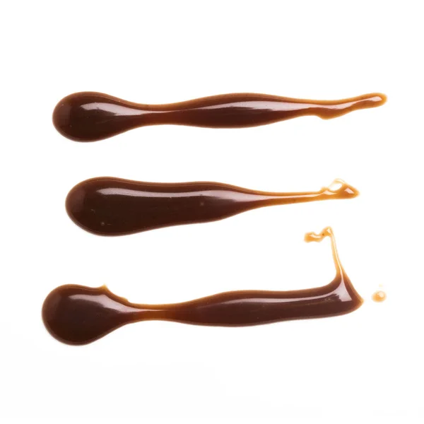 Listra de molho de caramelo de chocolate em um fundo branco liso — Fotografia de Stock